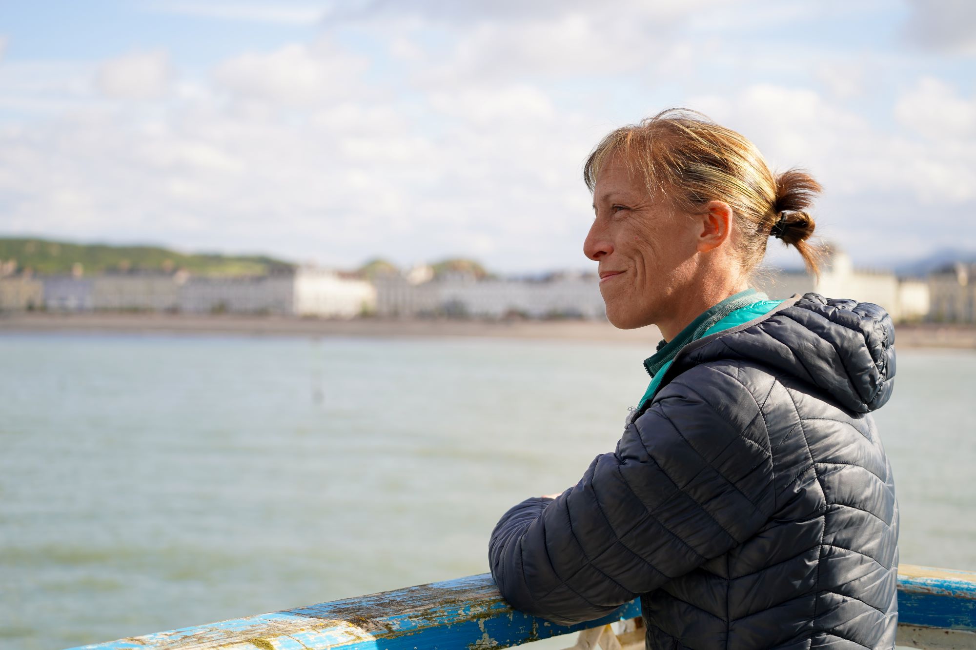 a lady looking out to the sea, admiring the view
